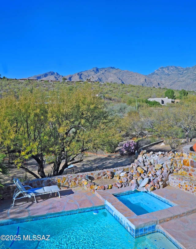 view of pool with a mountain view and an in ground hot tub