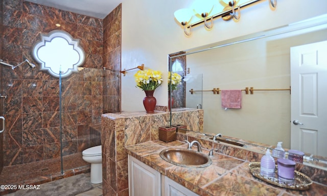 bathroom featuring tile patterned flooring, a tile shower, vanity, and toilet