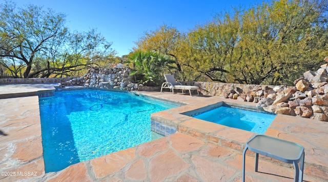 view of pool featuring an in ground hot tub