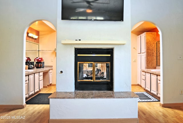 interior details featuring a multi sided fireplace and hardwood / wood-style floors