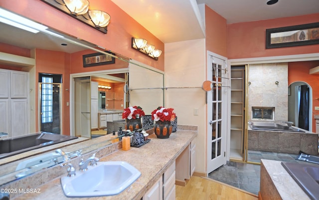 bathroom featuring hardwood / wood-style floors, vanity, and a washtub