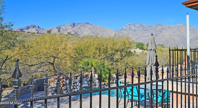 view of gate with a fenced in pool and a mountain view