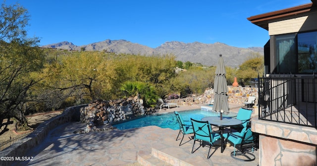 view of pool featuring a mountain view and a patio