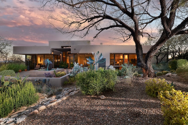 back house at dusk with a patio