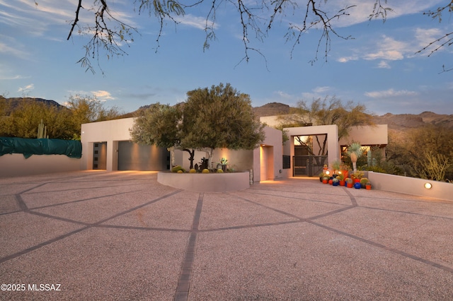 pueblo-style house with a garage and a mountain view