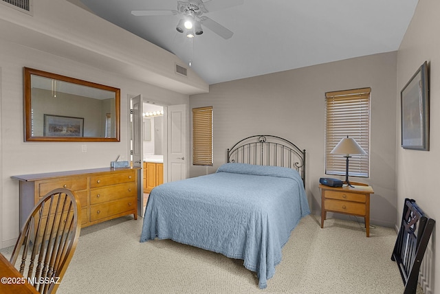 bedroom with ensuite bathroom, ceiling fan, light colored carpet, and lofted ceiling