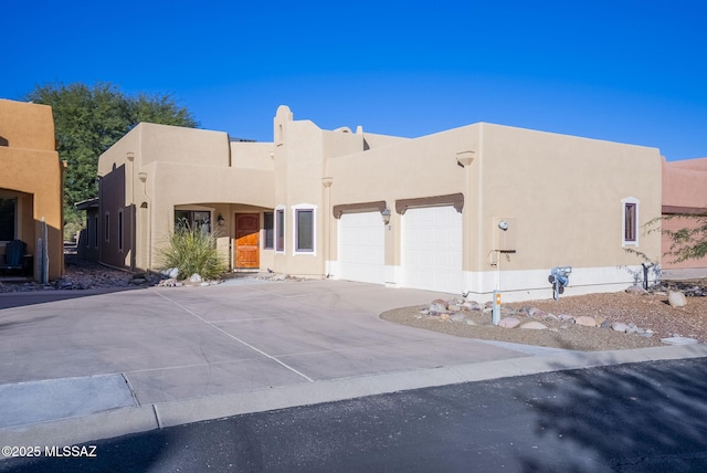 pueblo-style house featuring a garage