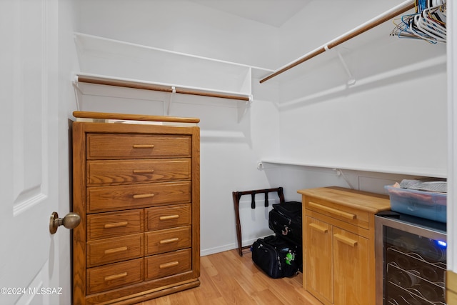 walk in closet featuring light hardwood / wood-style floors and beverage cooler