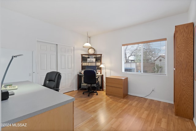 home office with light hardwood / wood-style floors