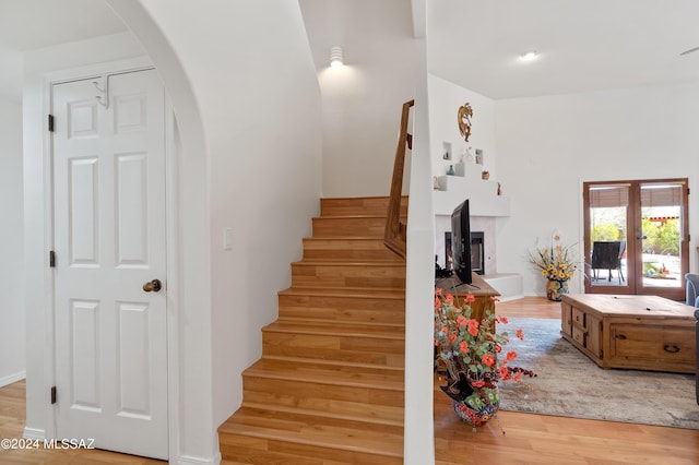 staircase with hardwood / wood-style floors and french doors