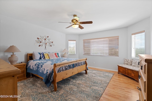 bedroom featuring multiple windows, ceiling fan, and wood-type flooring