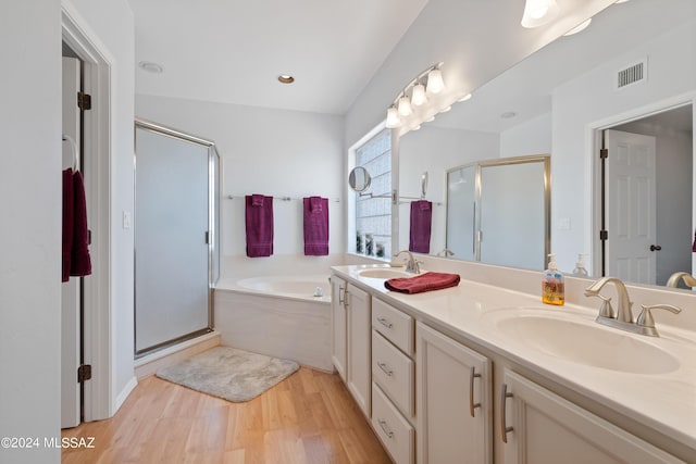 bathroom featuring hardwood / wood-style flooring, vanity, and shower with separate bathtub