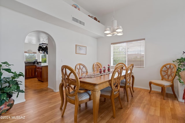 dining area featuring a chandelier, light wood-type flooring, and plenty of natural light