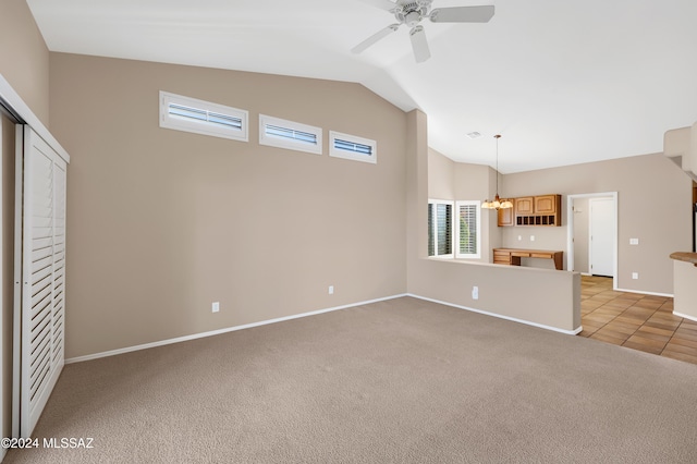 unfurnished living room with ceiling fan with notable chandelier, light colored carpet, and lofted ceiling