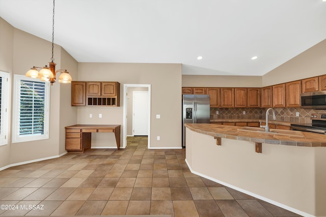 kitchen with stainless steel appliances, tasteful backsplash, a chandelier, vaulted ceiling, and decorative light fixtures