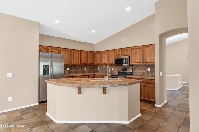 kitchen featuring tasteful backsplash, stainless steel appliances, sink, a center island with sink, and a breakfast bar area