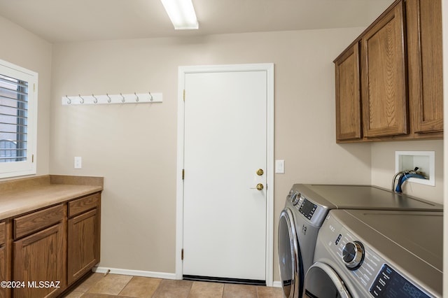 laundry room featuring separate washer and dryer, light tile patterned flooring, and cabinets