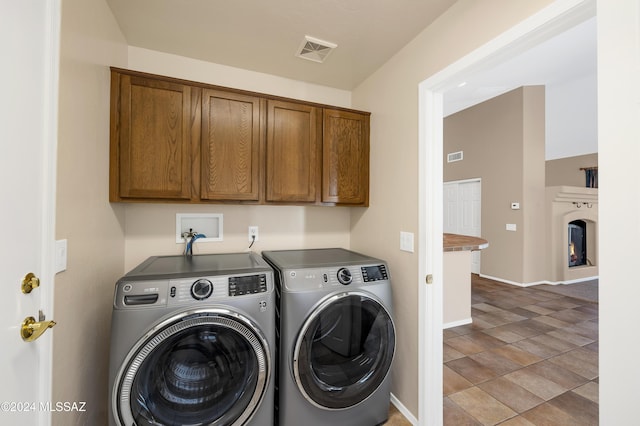 clothes washing area with cabinets and independent washer and dryer