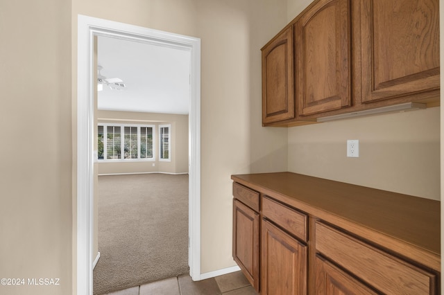 interior space with ceiling fan and light carpet