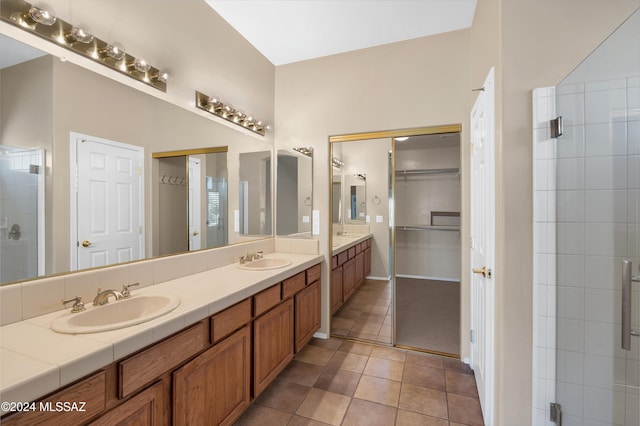 bathroom with tile patterned flooring, vanity, and walk in shower