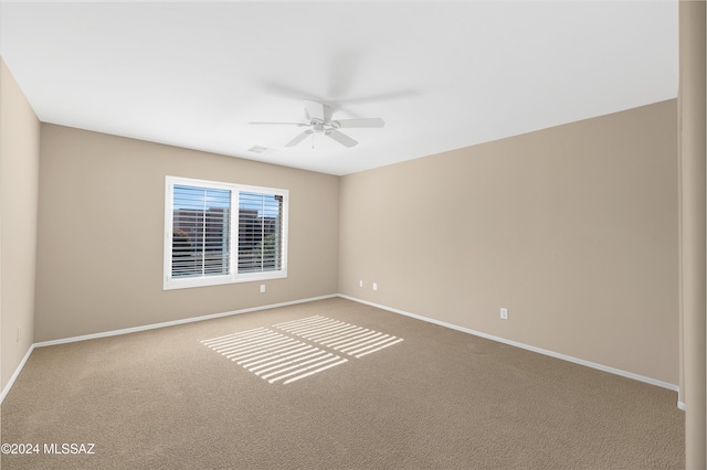 carpeted spare room featuring ceiling fan