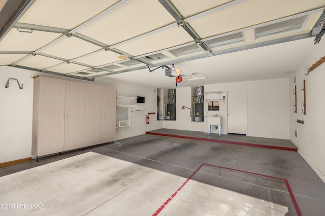 garage featuring electric panel, sink, and a garage door opener