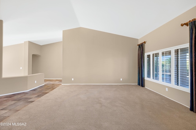 unfurnished room featuring light tile patterned floors and vaulted ceiling