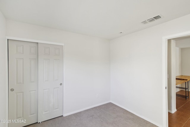 unfurnished bedroom with carpet flooring and a closet