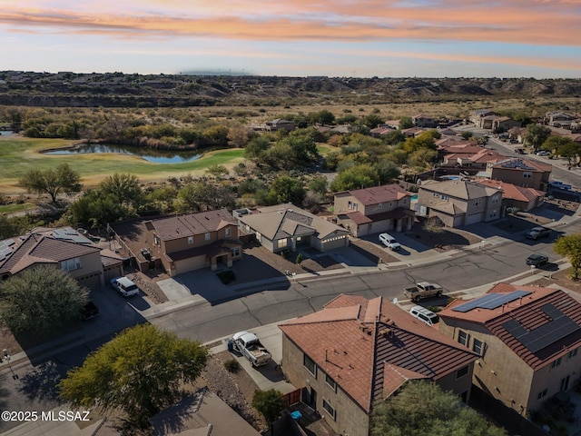 aerial view at dusk featuring a water view