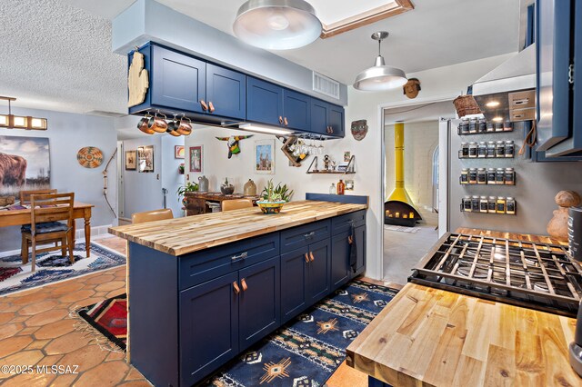 kitchen featuring gas stove, blue cabinets, and butcher block counters