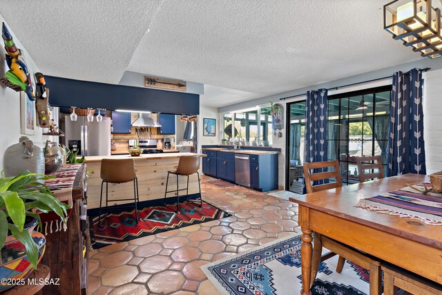 tiled dining area featuring baseboards, a textured ceiling, and visible vents