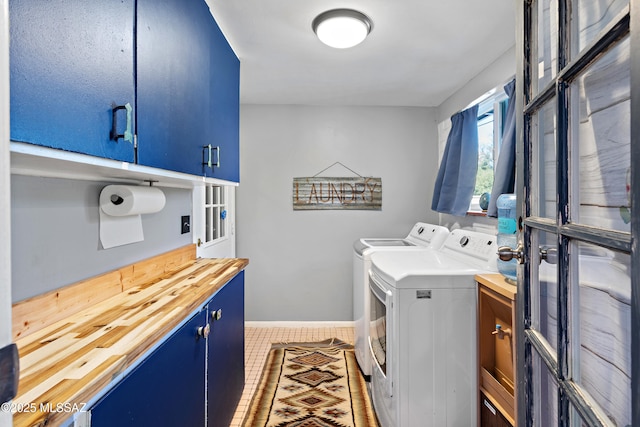 washroom with tile patterned flooring, washing machine and dryer, and cabinets