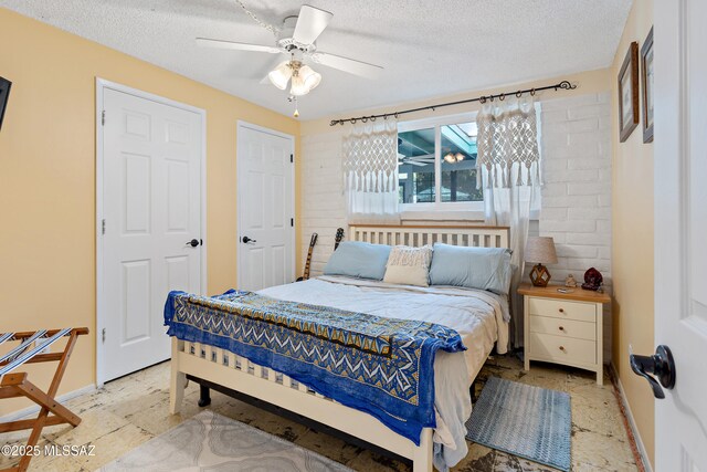 clothes washing area with cabinet space, baseboards, washing machine and dryer, and tile patterned floors