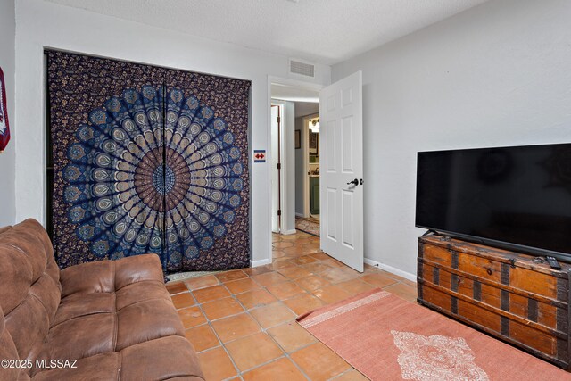 tiled bedroom with a textured ceiling and baseboards