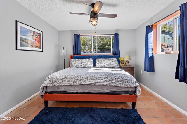 tiled living area featuring a textured ceiling, baseboards, and visible vents