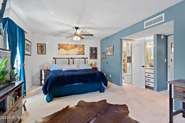 carpeted bedroom with brick wall, a ceiling fan, and a textured ceiling