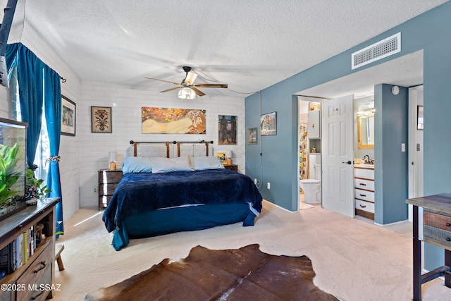 bedroom with sink, light carpet, and a textured ceiling