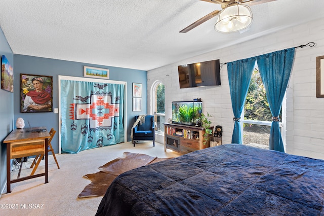 carpeted bedroom featuring brick wall and a textured ceiling