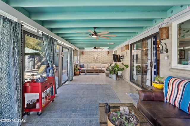 sunroom / solarium with beamed ceiling and ceiling fan