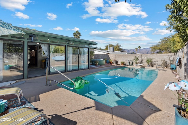 view of swimming pool featuring a patio and a mountain view