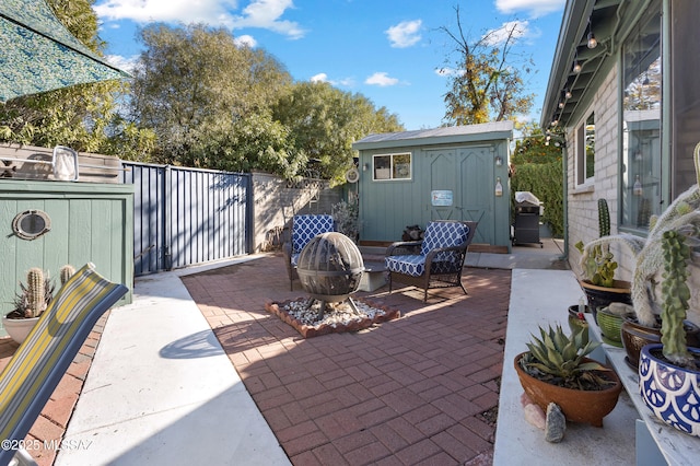 view of patio / terrace with grilling area, a shed, and a fire pit