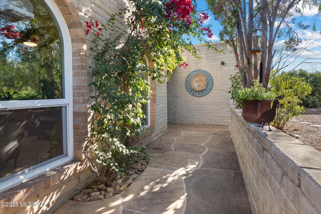 view of property exterior featuring fence and brick siding