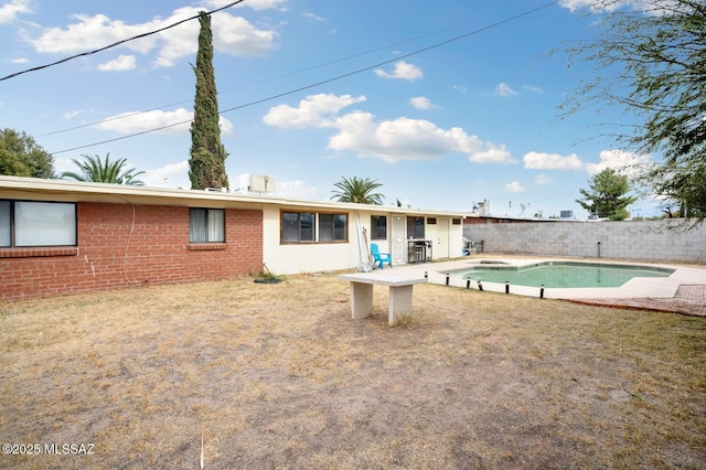 back of property featuring a fenced in pool and a patio area