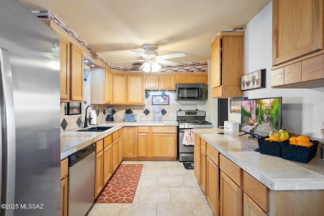 kitchen featuring sink, ceiling fan, appliances with stainless steel finishes, light tile patterned flooring, and decorative backsplash