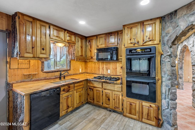 kitchen featuring black appliances, light hardwood / wood-style floors, and sink