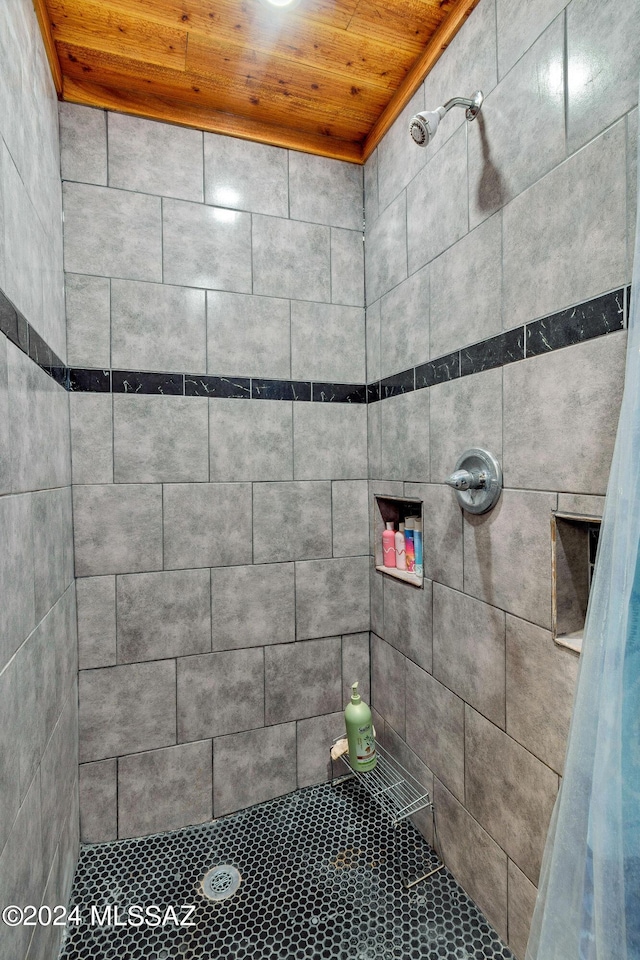 bathroom with wooden ceiling and tiled shower