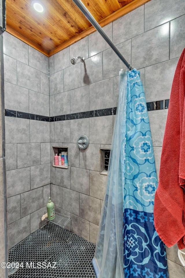 bathroom featuring a shower with shower curtain and wood ceiling