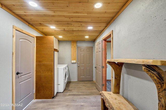 washroom featuring washing machine and dryer, wooden ceiling, and light hardwood / wood-style floors