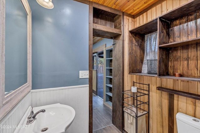 bathroom featuring wood-type flooring, toilet, wooden ceiling, and sink