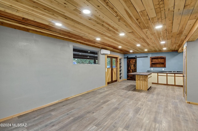 kitchen with a center island, wooden ceiling, a barn door, a wall mounted AC, and light wood-type flooring